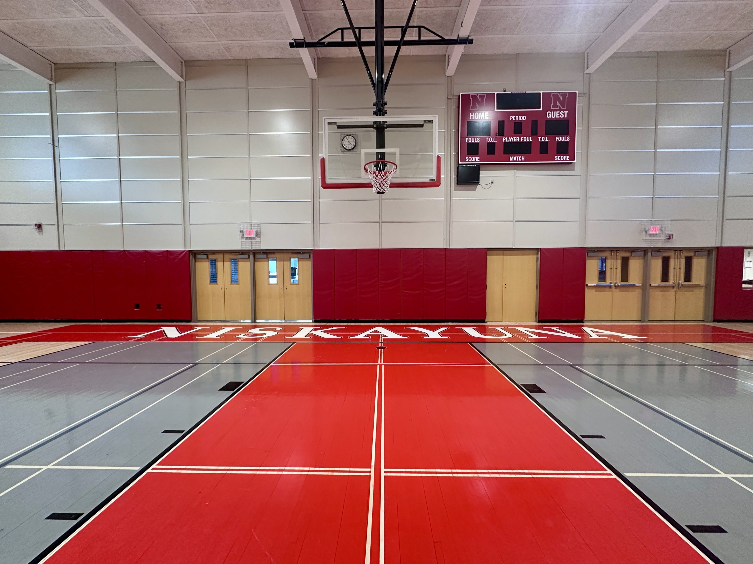 An empty gymnasium with Niskayuna painted on the floor.