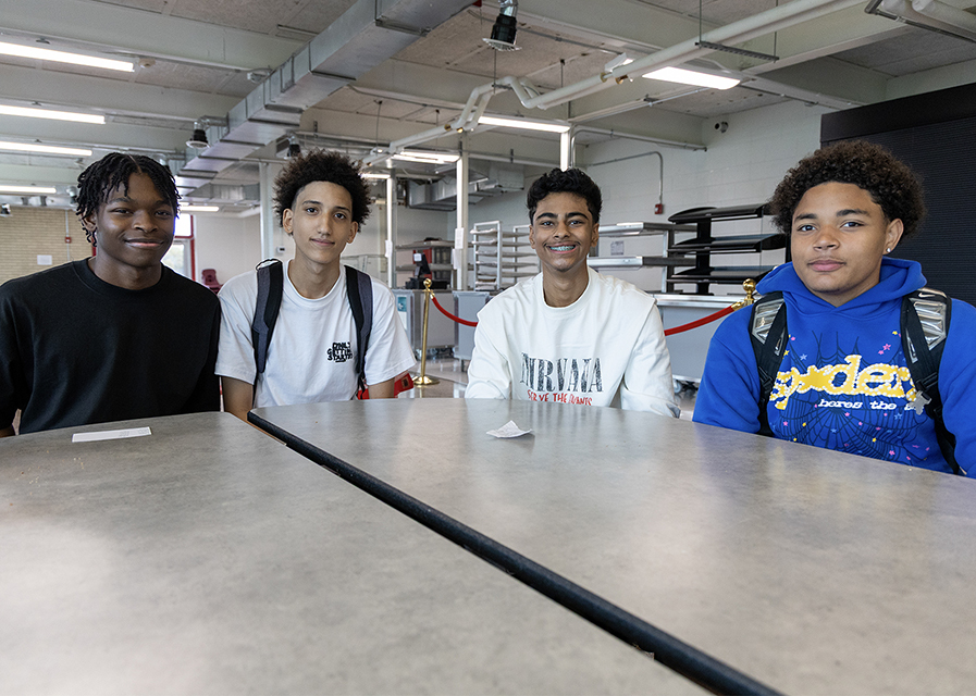 Four teens siting together at a table.