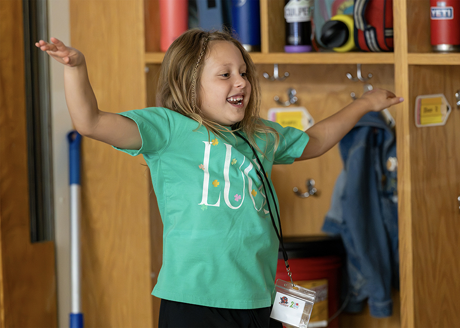 A young student dancing in a classroom.