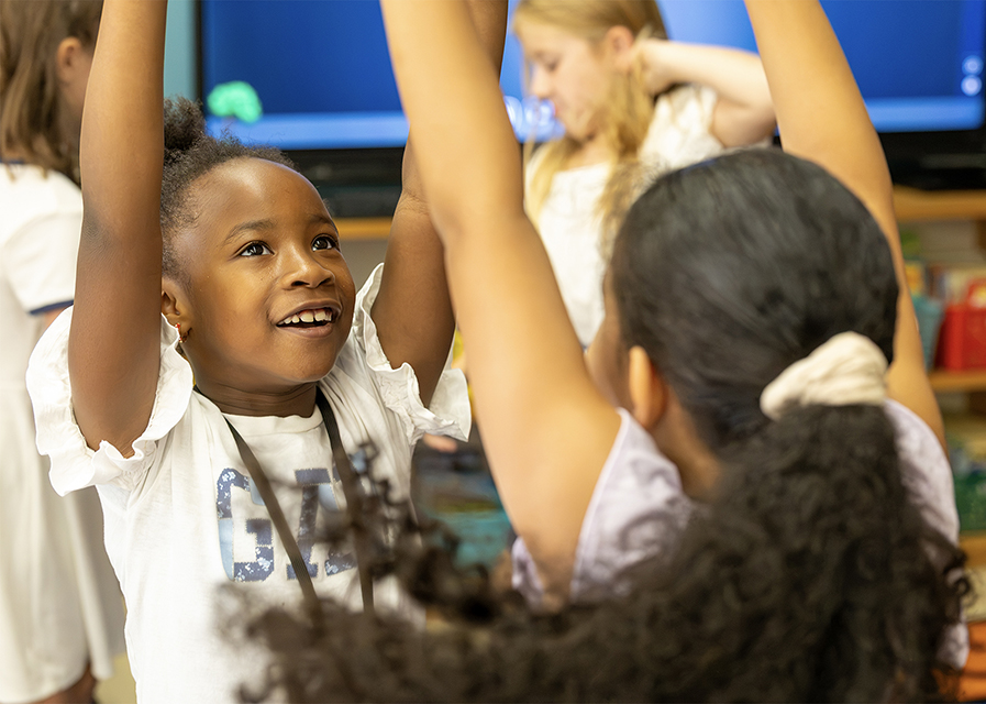 Two students raising this arms in class.