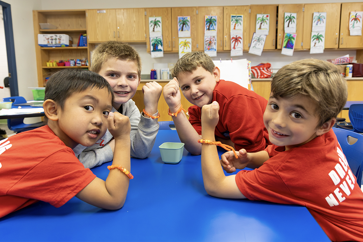 group of elementary buddies making bracelets