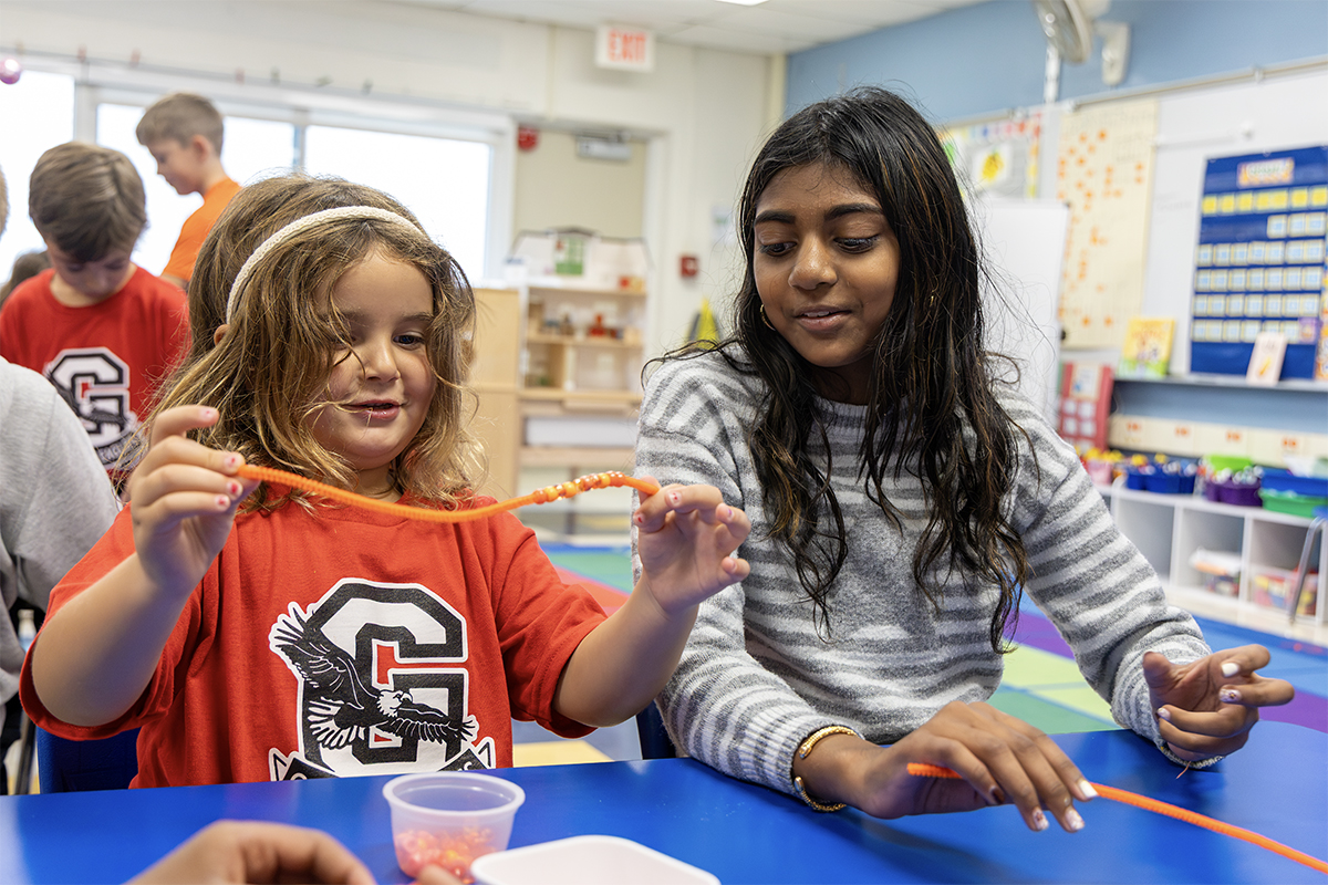elementary buddies making orange beaded bracelets
