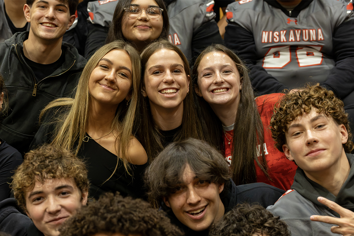 high school students smile at pep rally