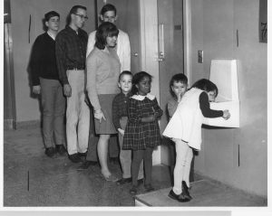 High school and kindergarten students stand in line to use a water fountain at Niskayuna High School in the 1960s.