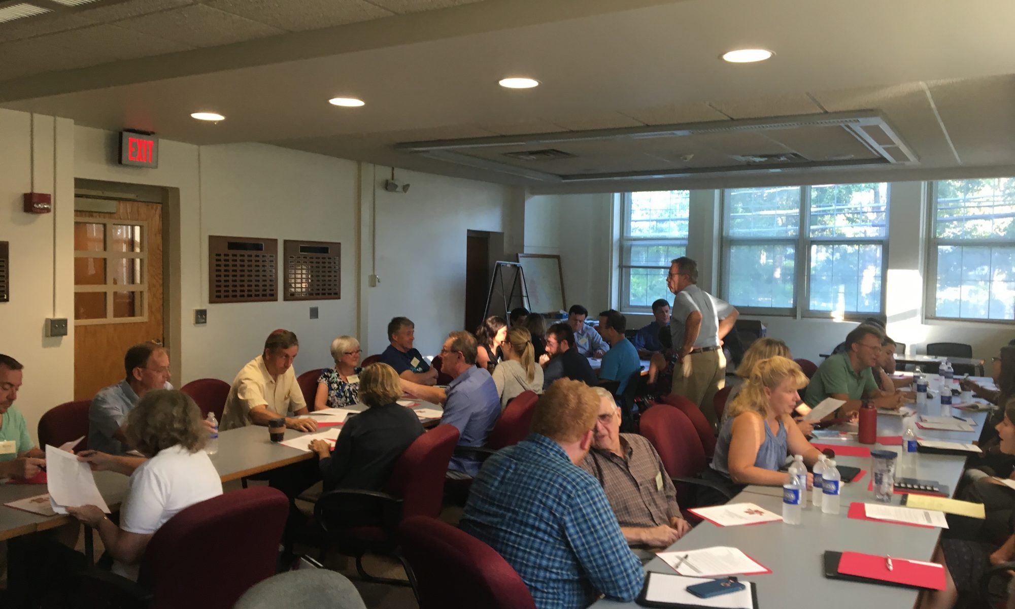 Members of the Capital Project Community Advisory Committee sit at tables and talk.