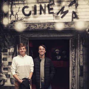 Two students stand in front of a cinemma