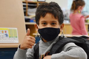 photo of an elementary student giving a thumbs up