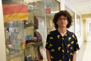 Sophomore Jesse Angrist stands in front of a display case in the hallway of Niskayuna High School that holds a German flag.
