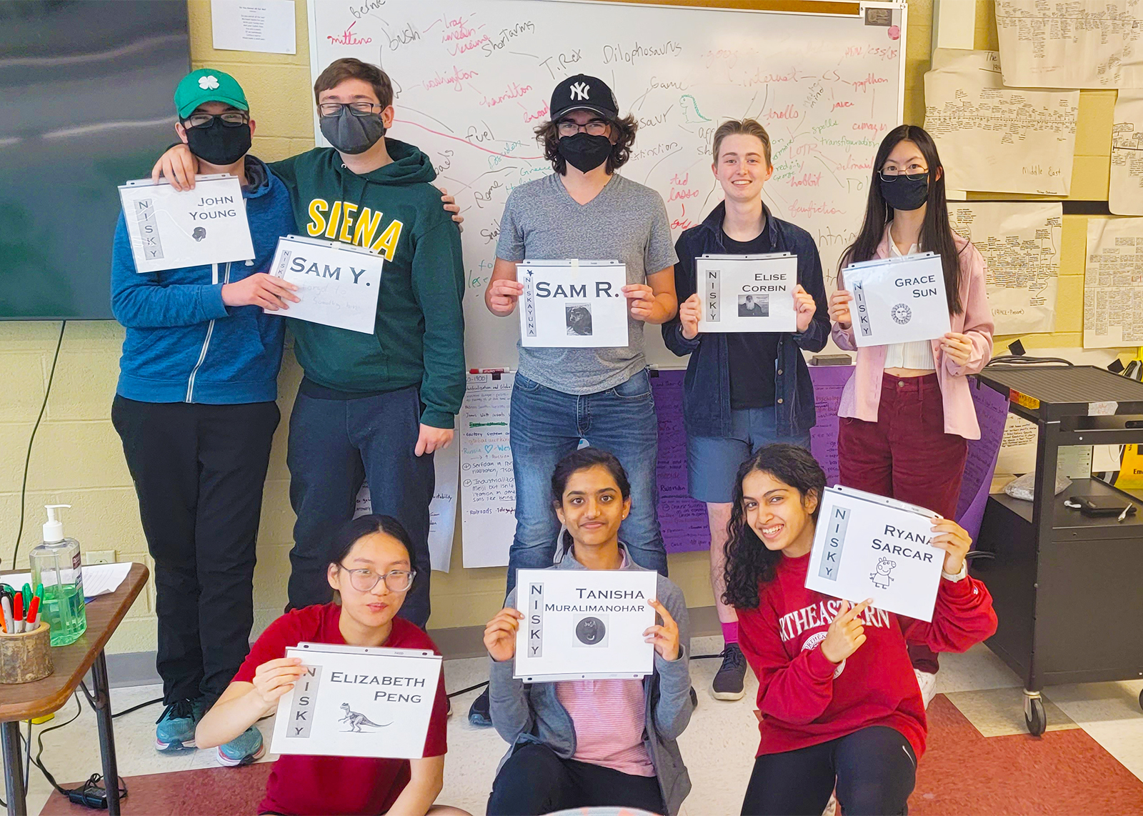 Masterminds team of 8 students smiling at camera holding up certificates