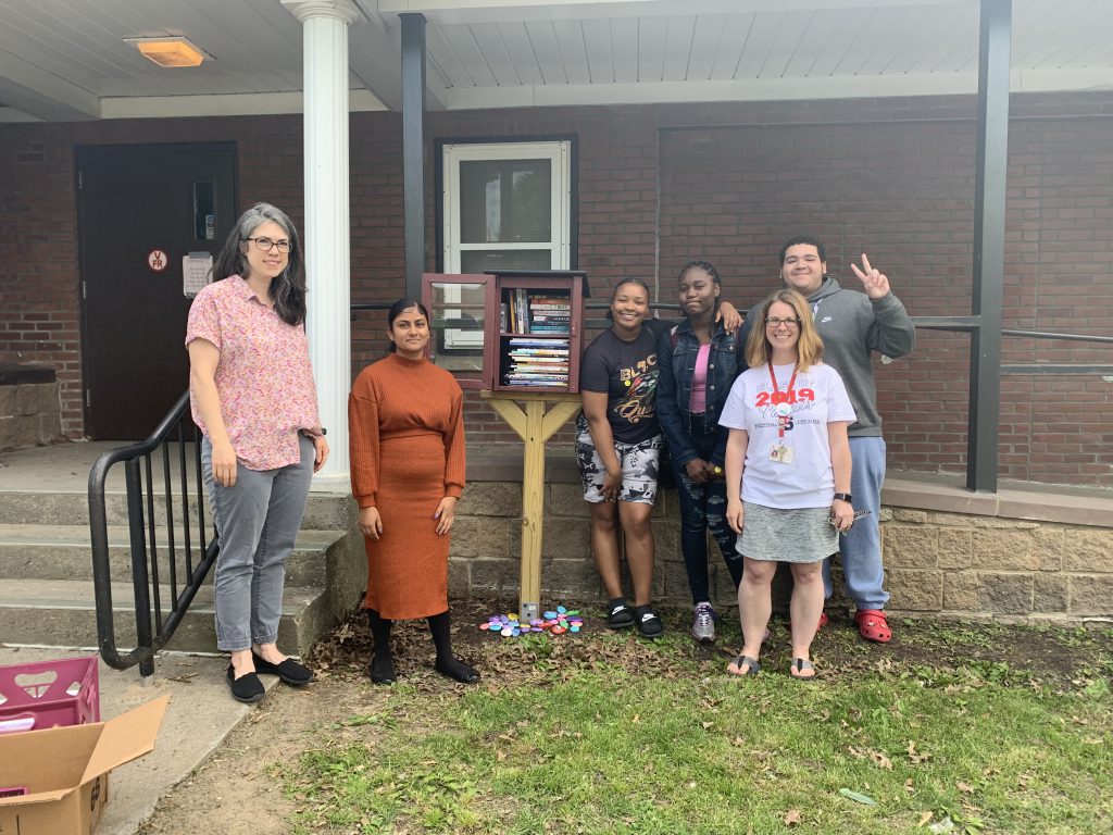Students and teachers posing with little free library