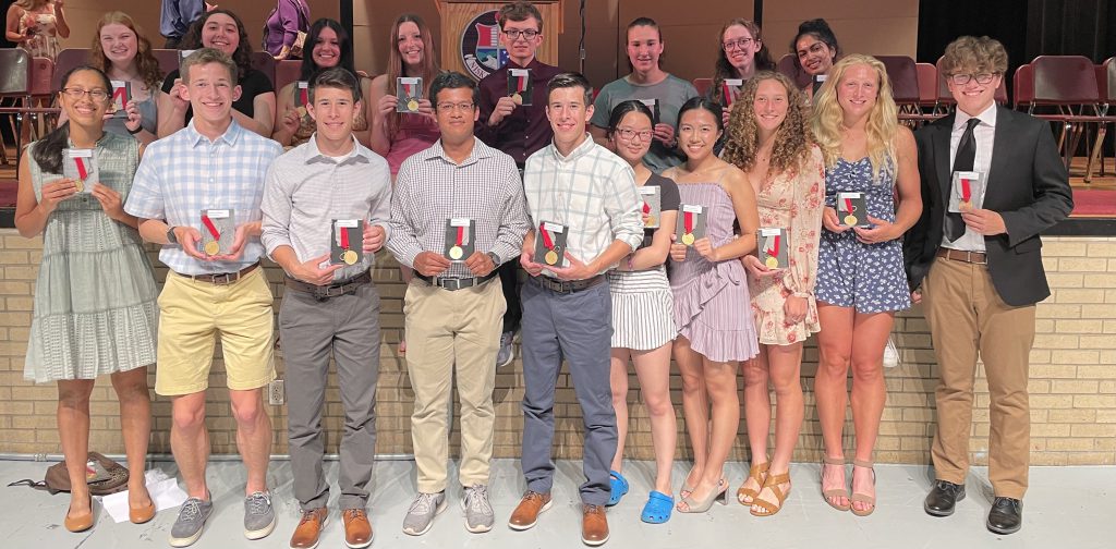 The students who received the 2022 Medal of Academic Excellence pose in the high school auditorium with their medals