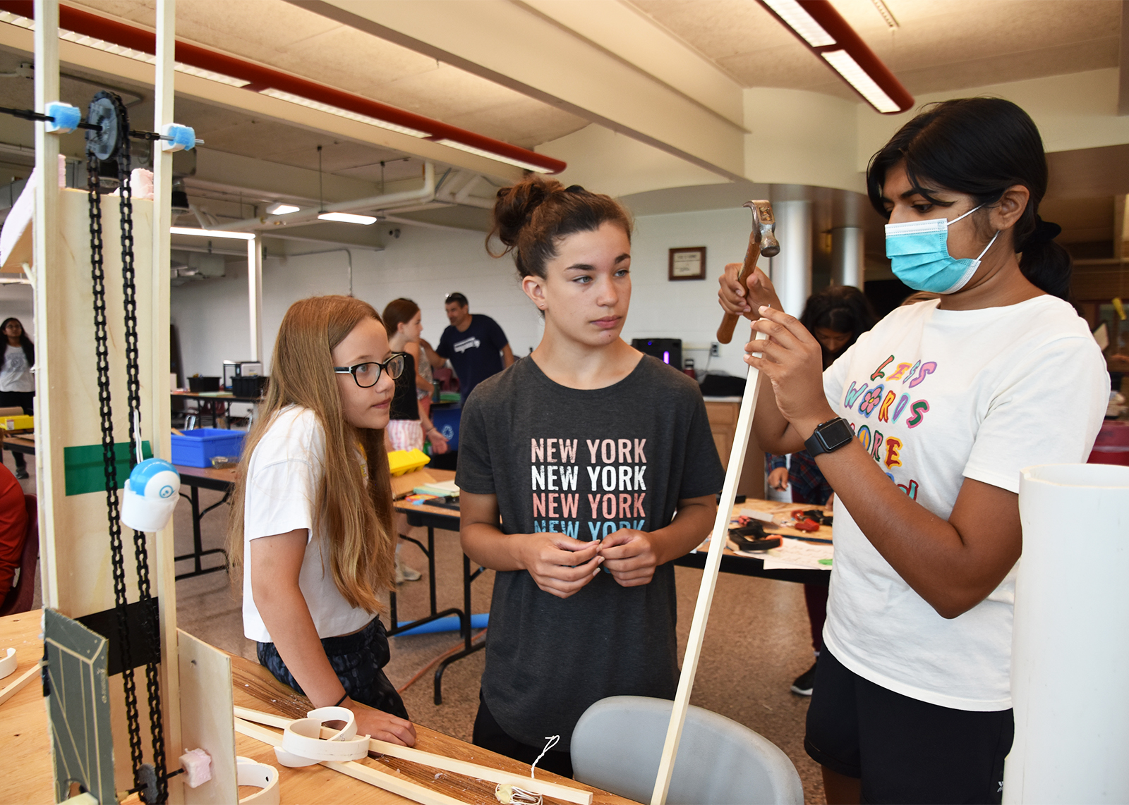 three students at engineering camp working on a project