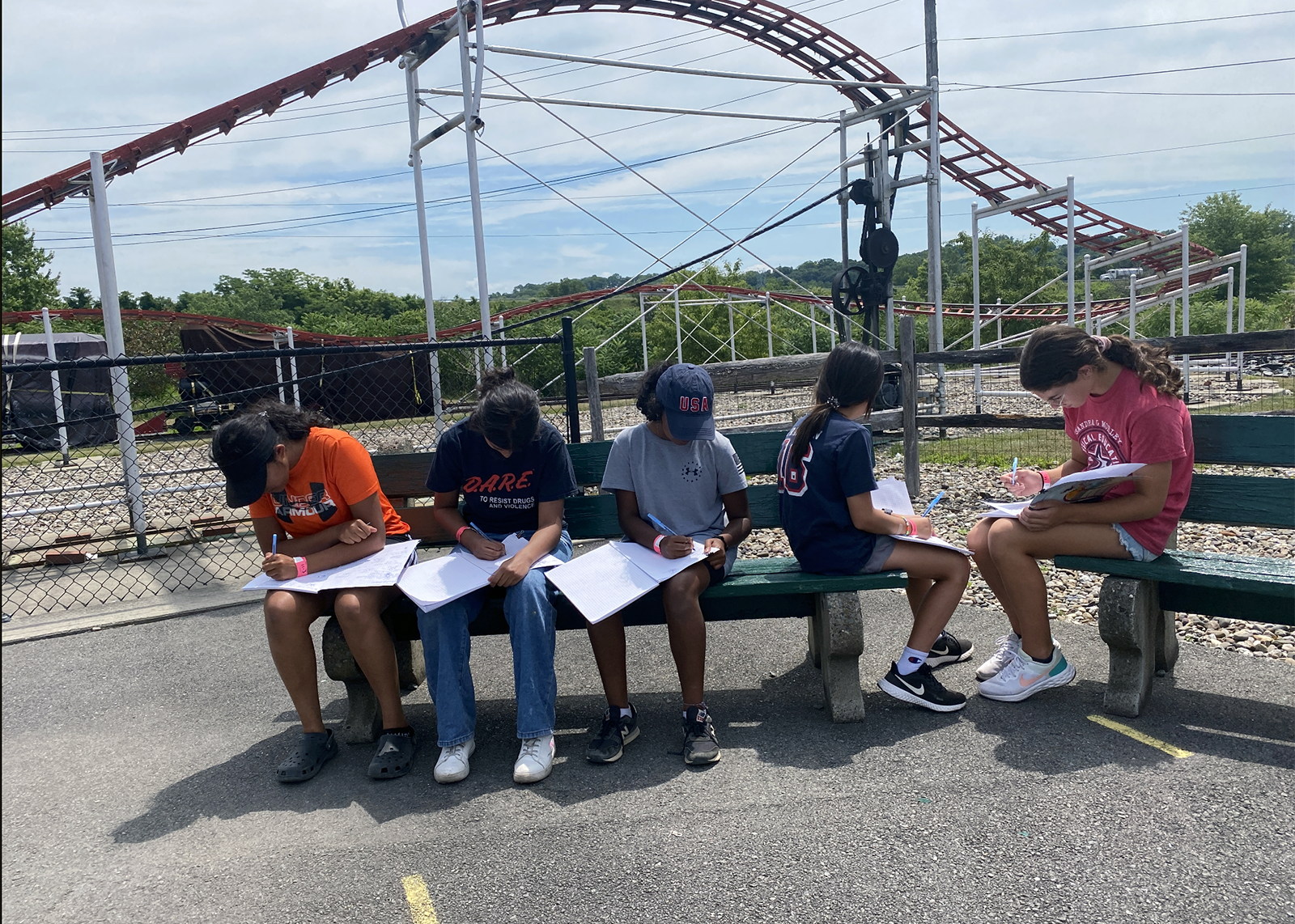 four students doing 4G research at in front of a rollercoaster