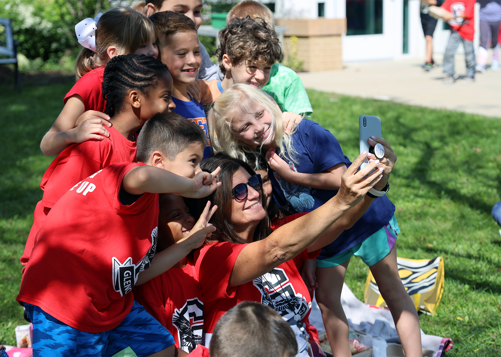 group of students outside take a selfie with the teacher