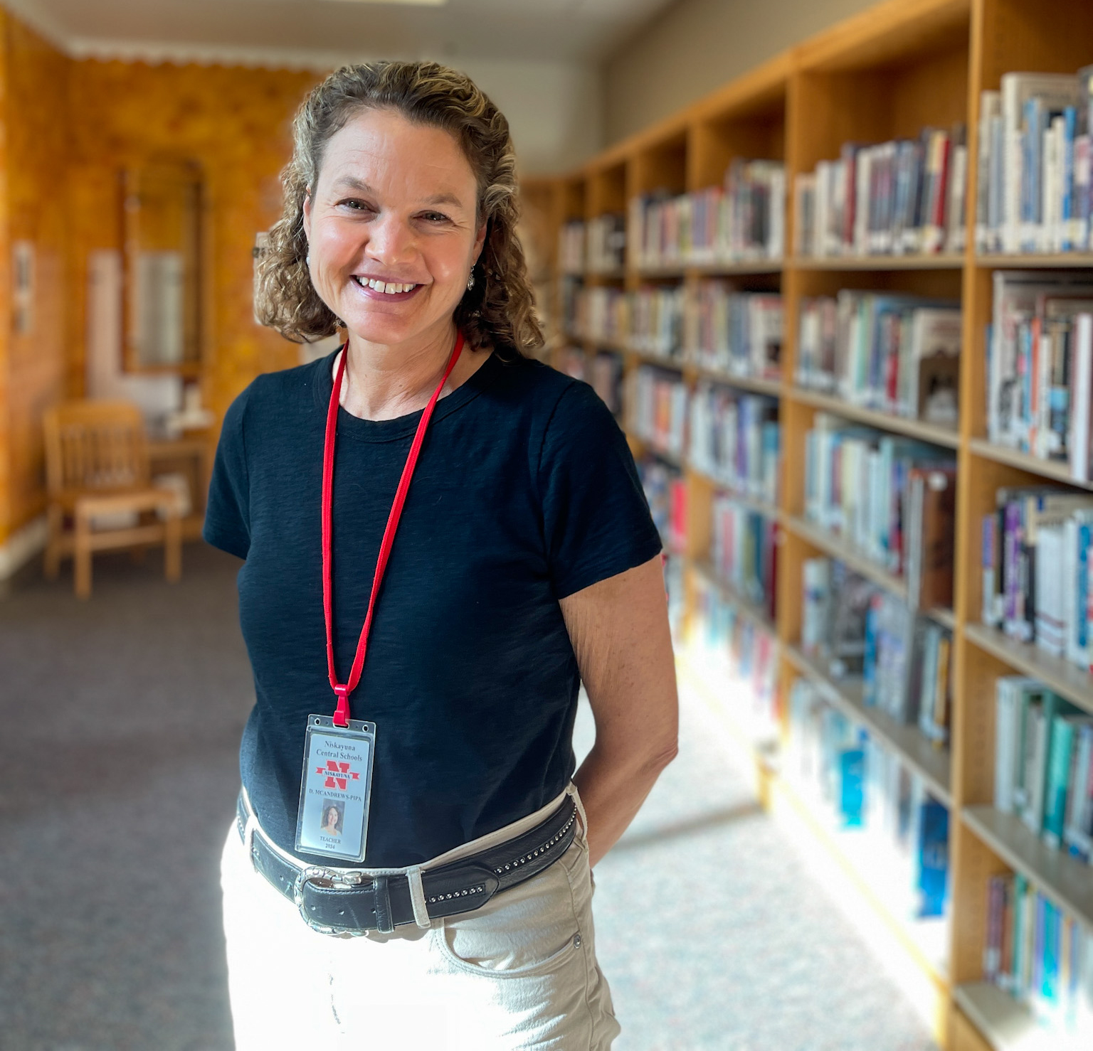 Donna McAndrews standing in library.