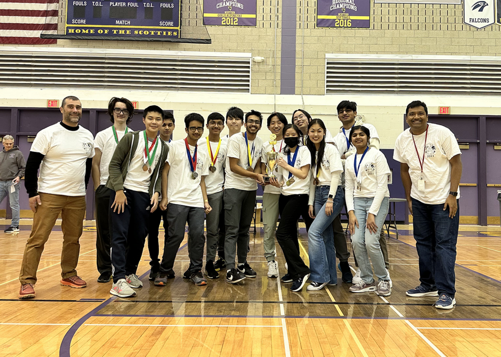 science olympiad group with coaches and trophy in gym