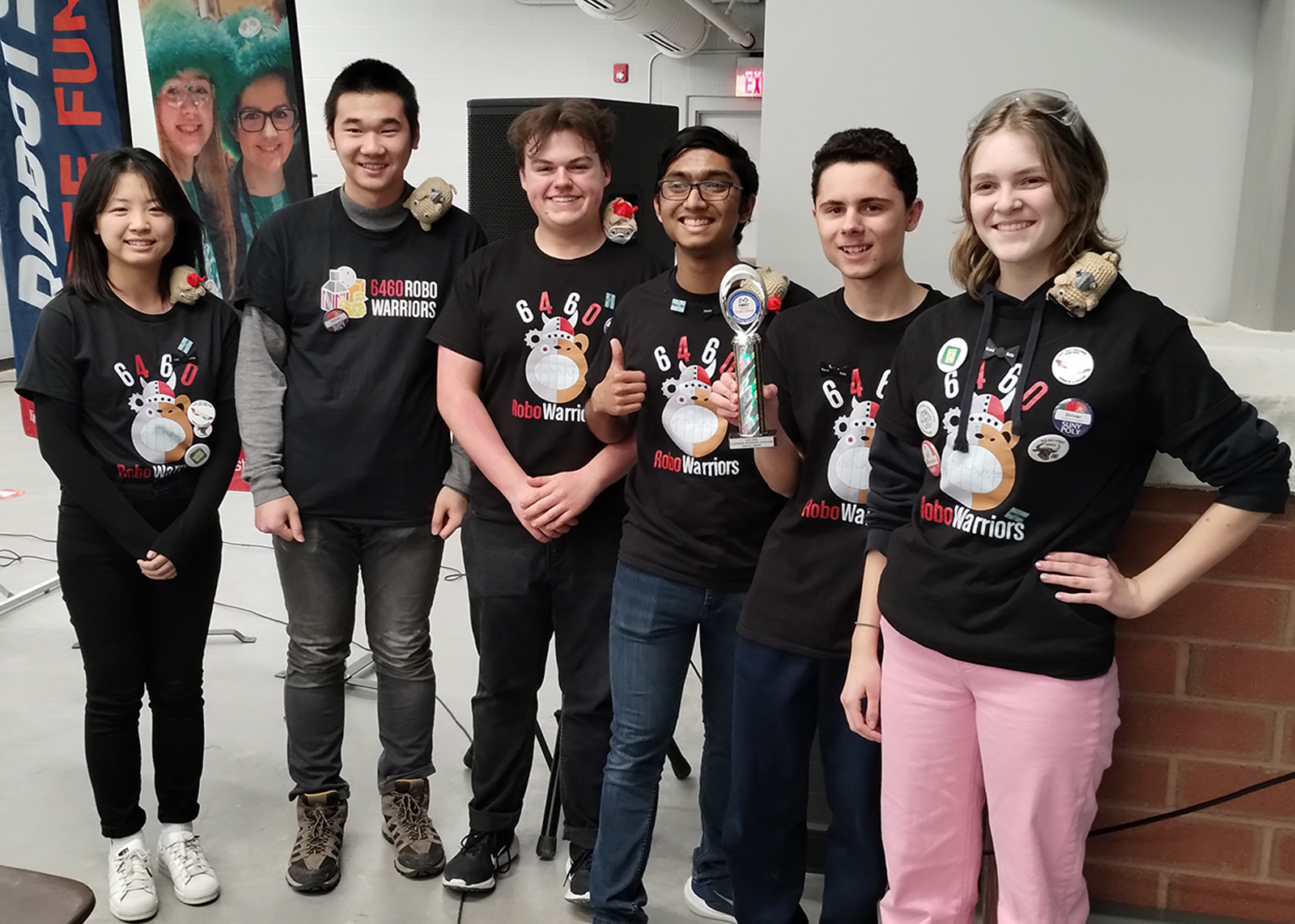 robotics team smiles while holding trophy