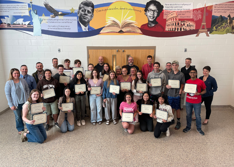 Numerous students gather with certificates