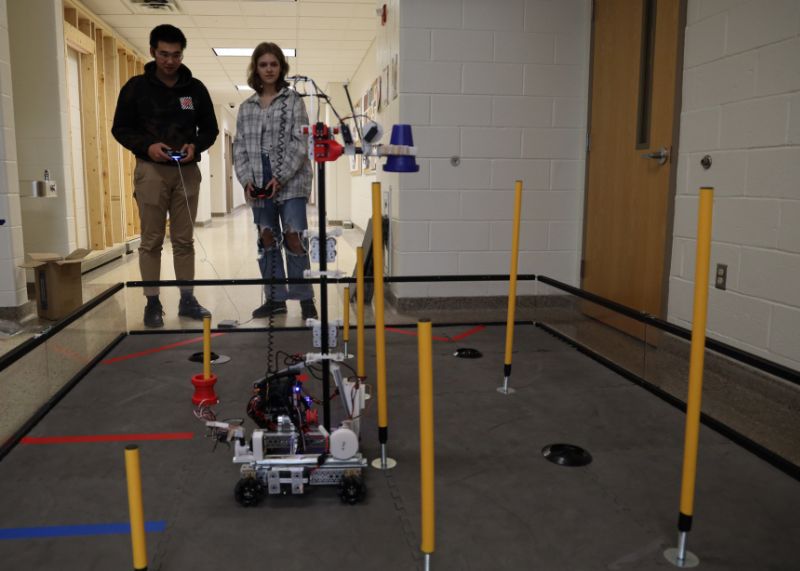Two students controlling robots