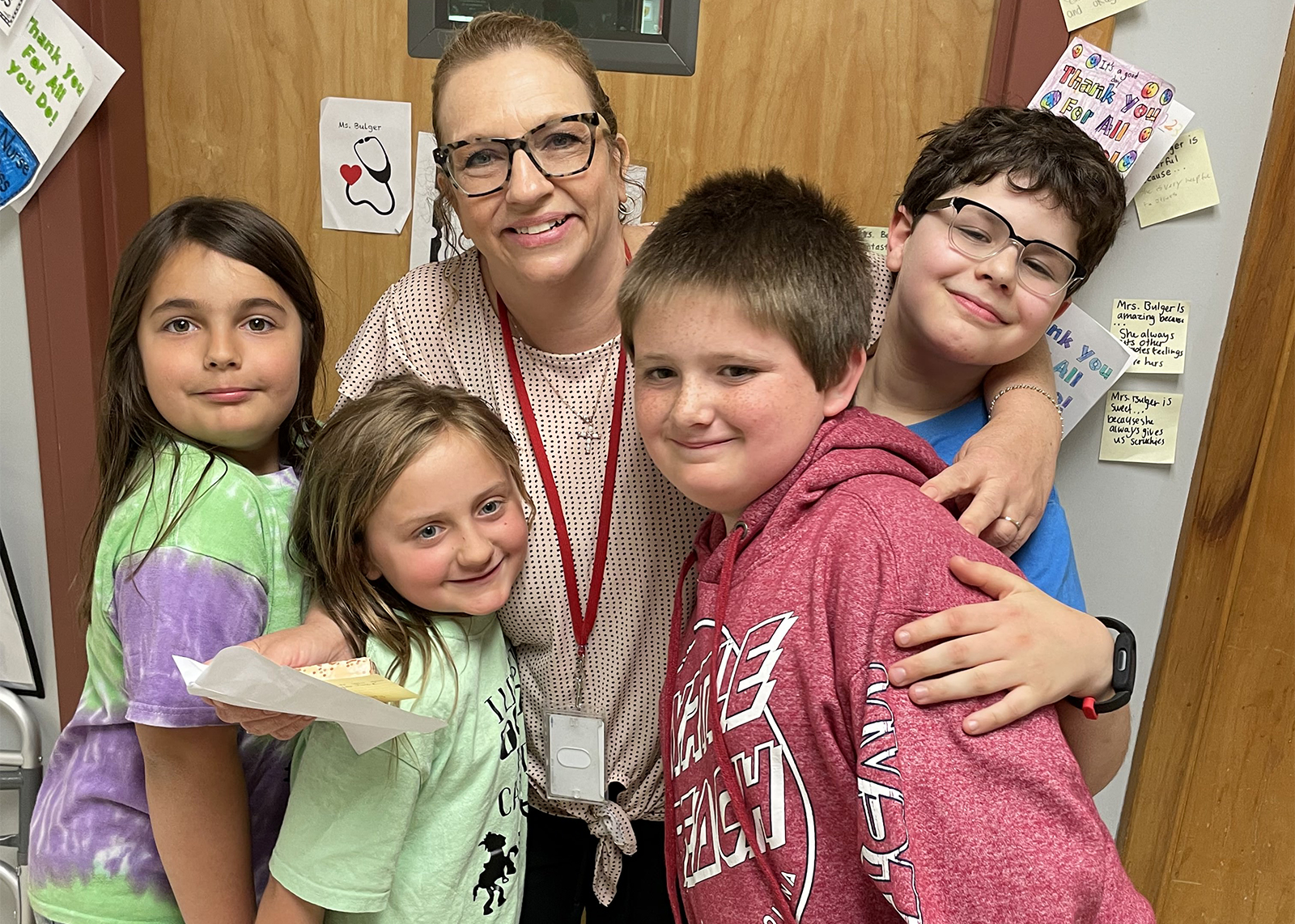 students hug school nurse