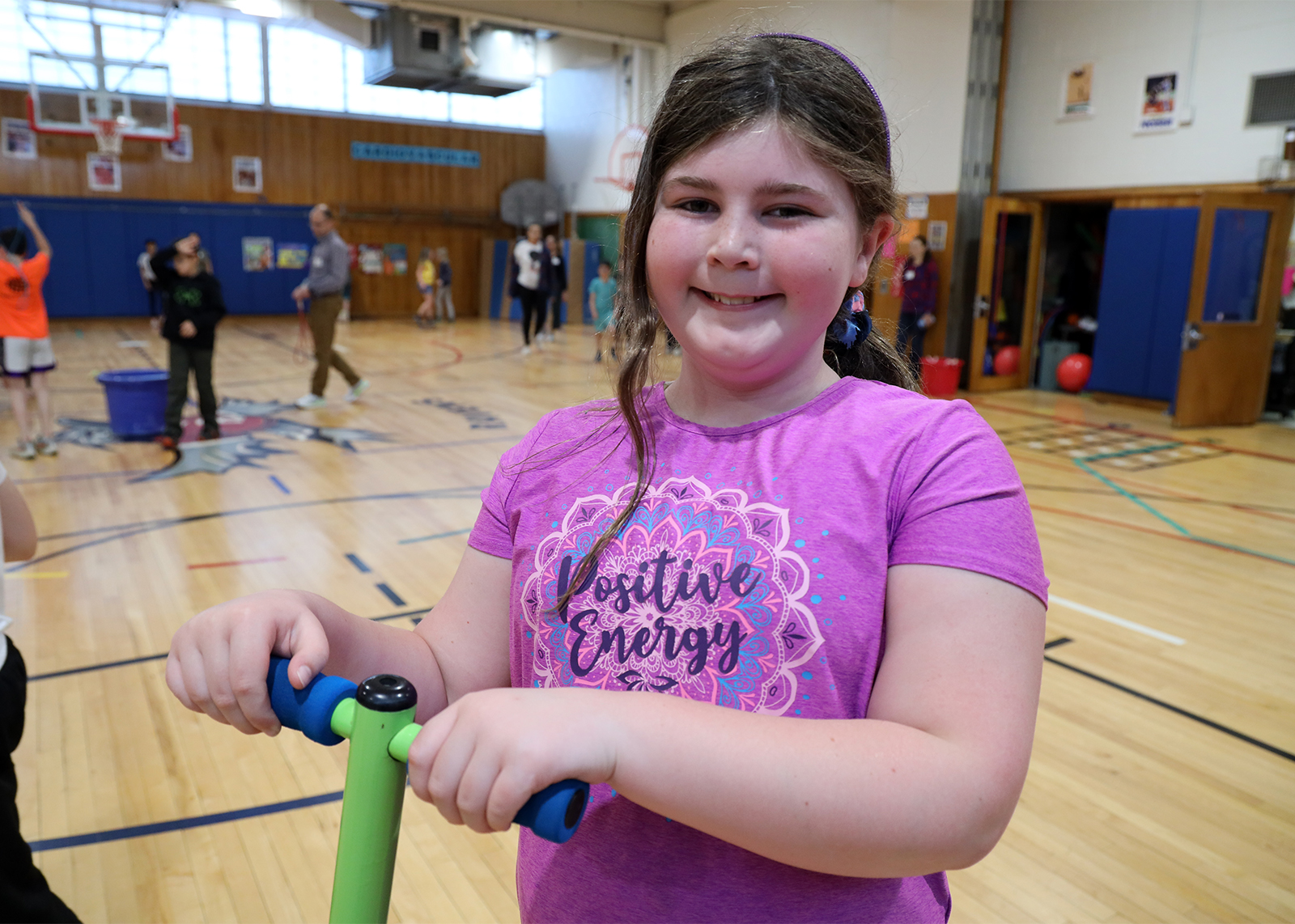 student holding a pogo stick smiling