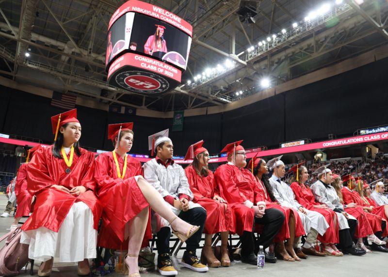 Students in cap and gown sitting in a row