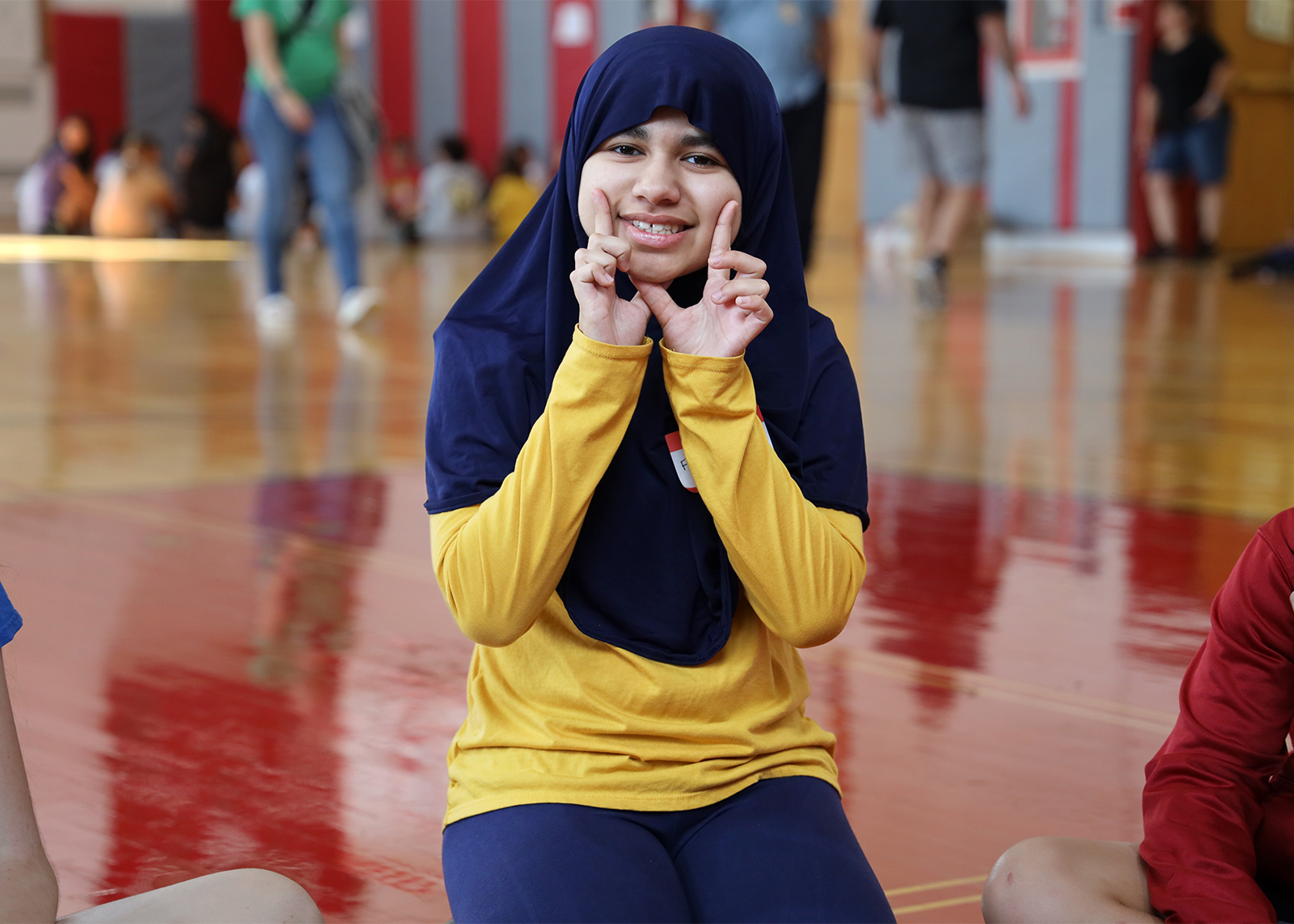 student smiling at camera in gymnasium