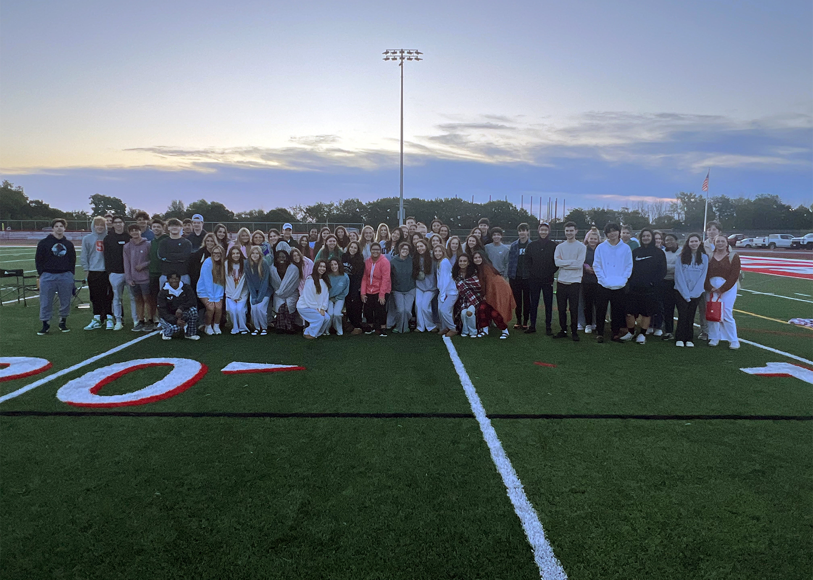 group of seniors on football field at sun rise