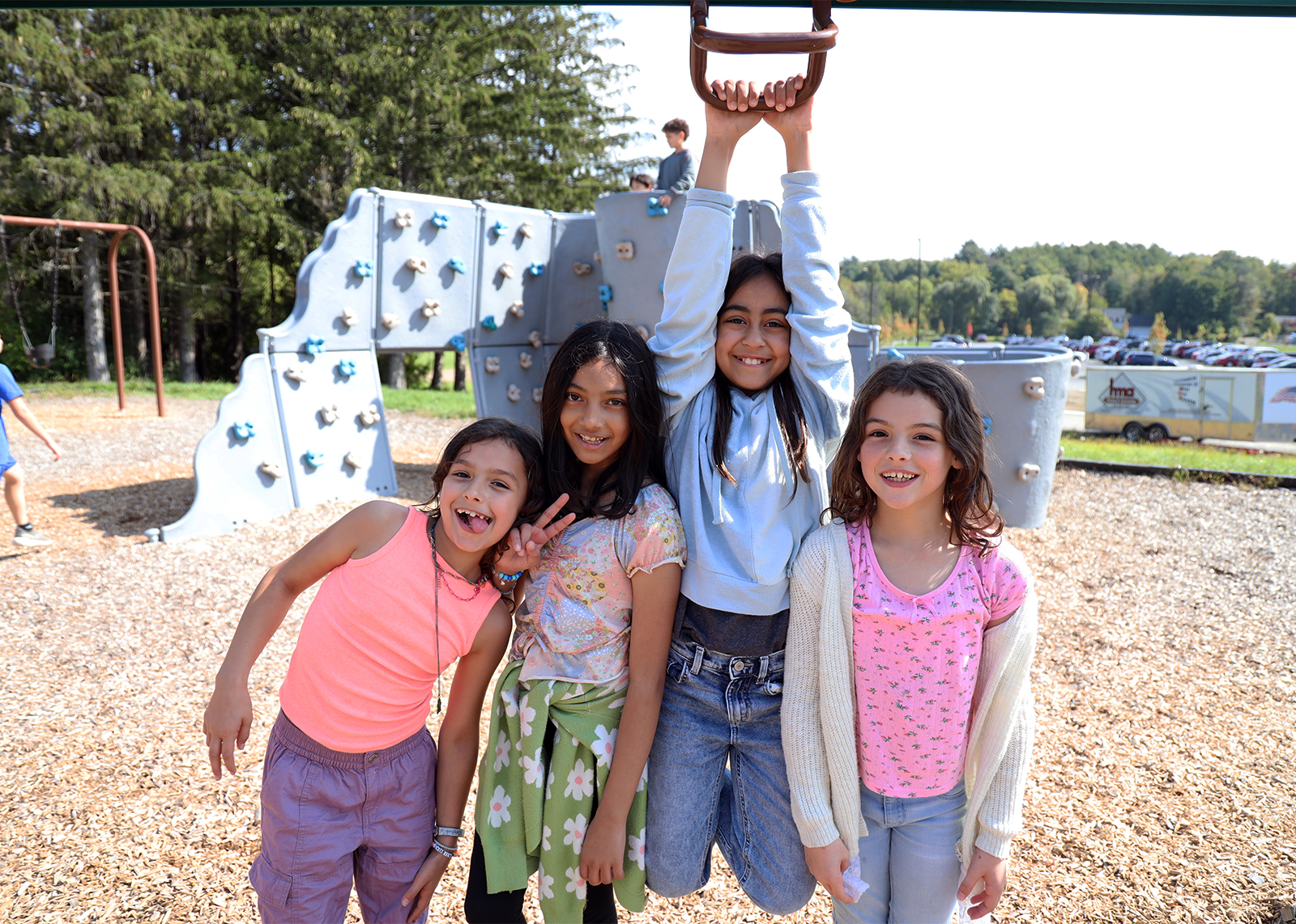 group of elementary students smile while on the playground