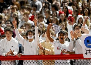 student section cheers with signs and pom poms