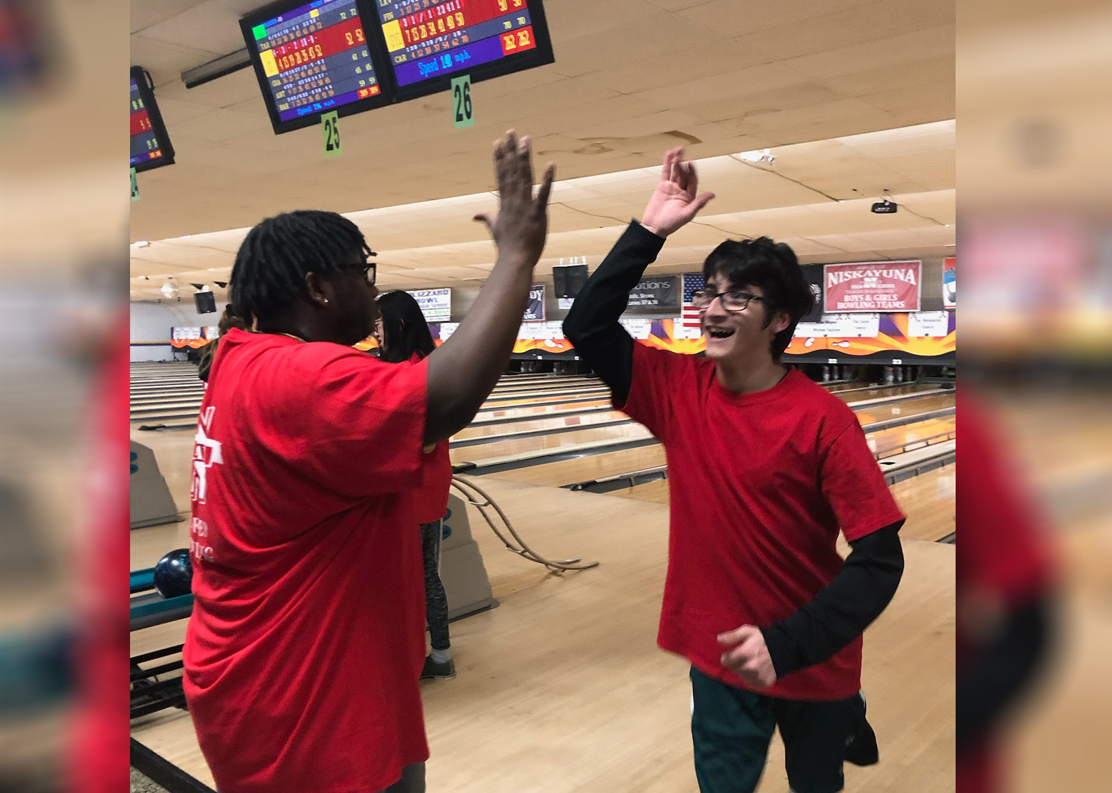 Unified Bowlers Ame Bender and Noah Bechtel share a high-five.