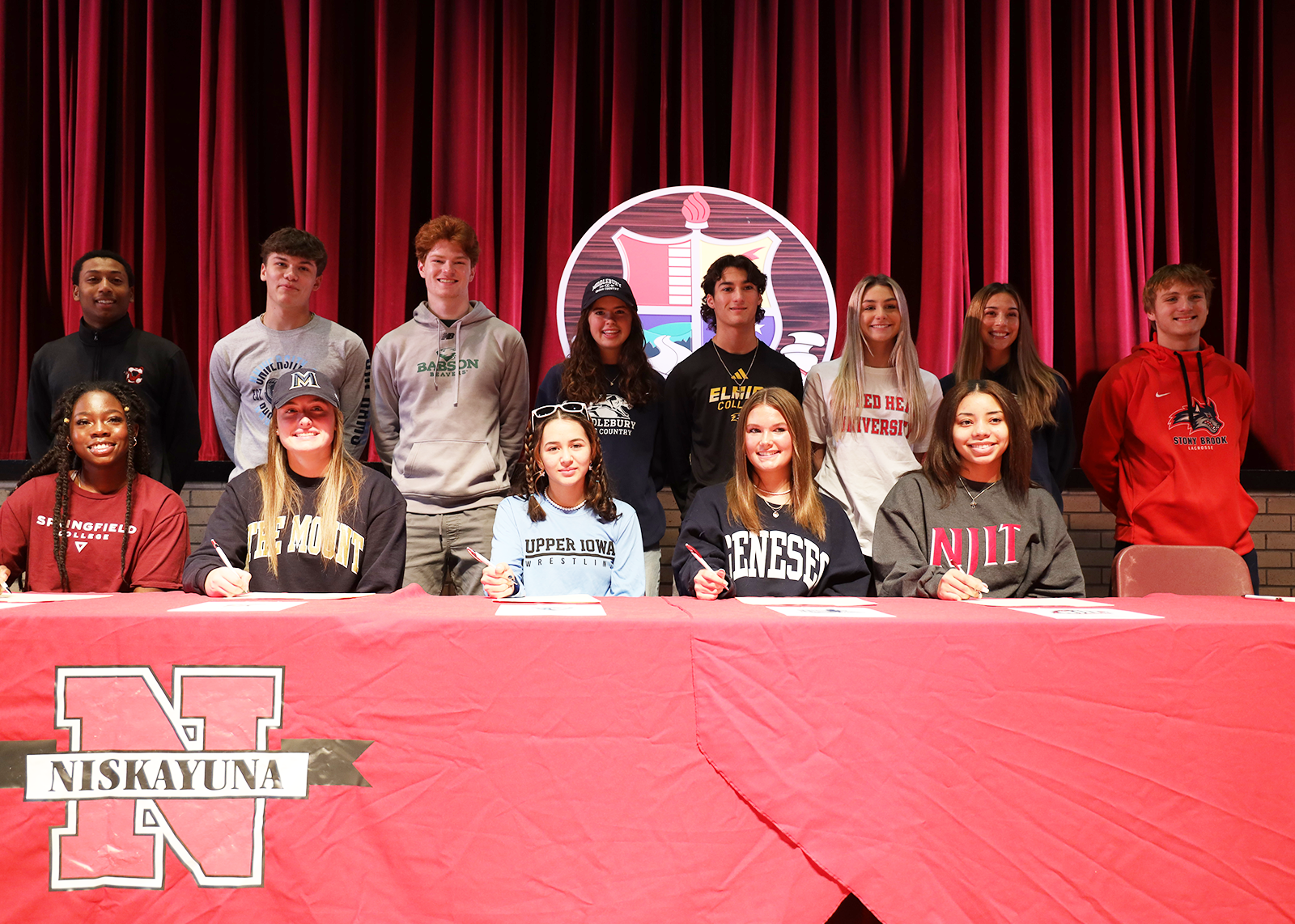 group of student athletes signing letters of intent