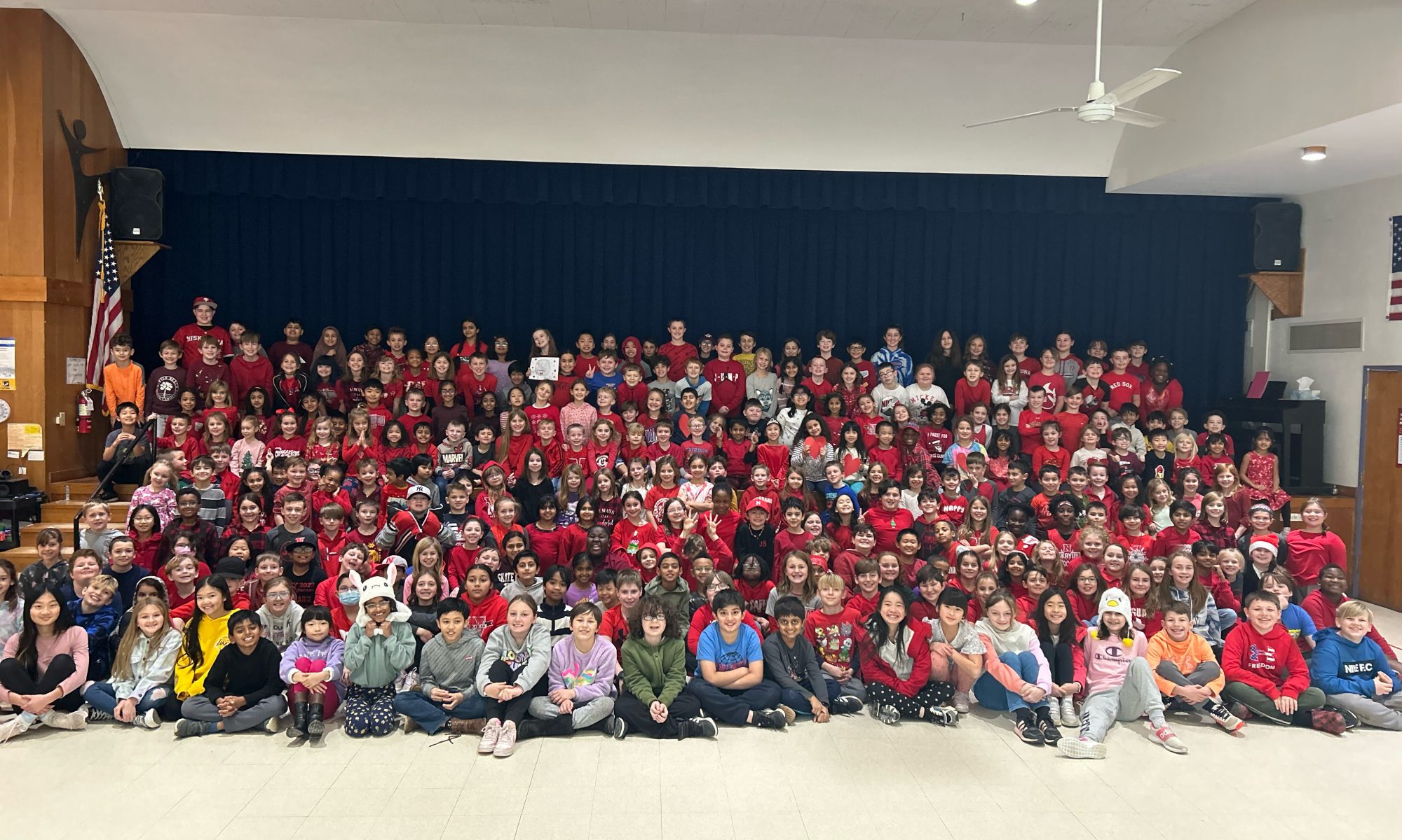 Large assembly of students wearing red