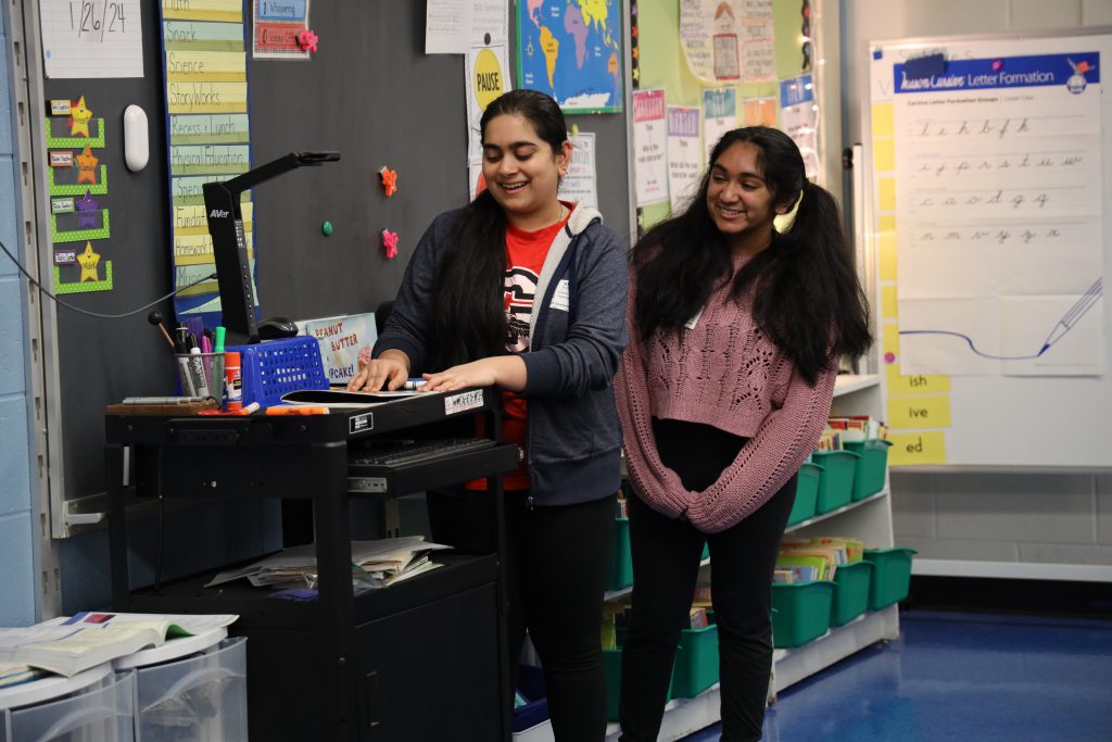 Sravani Nimishakavi and Shreejaa Senthilkumar read "Le Petit Chaperon Rouge" (Little Red Riding Hood) to students at Glencliff.