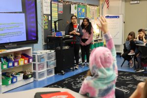NHS French students Sravani Nimishakavi and Shreejaa Senthilkumar read "Le Petit Chaperon Rouge" (Little Red Riding Hood) to students at Glencliff.