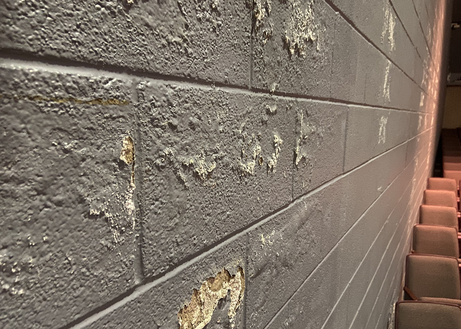 peeling paint on high school auditorium wall