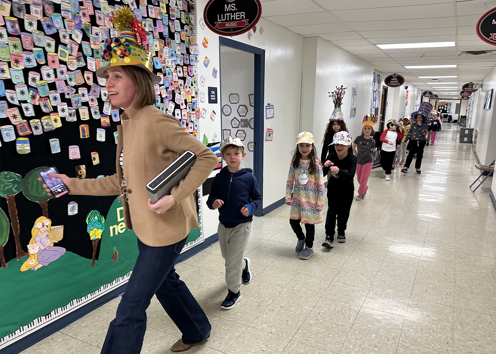 first graders with funny hats doing a parade through the halls
