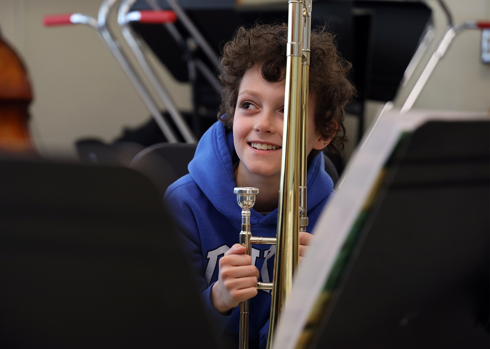 student holding trumpet smiling