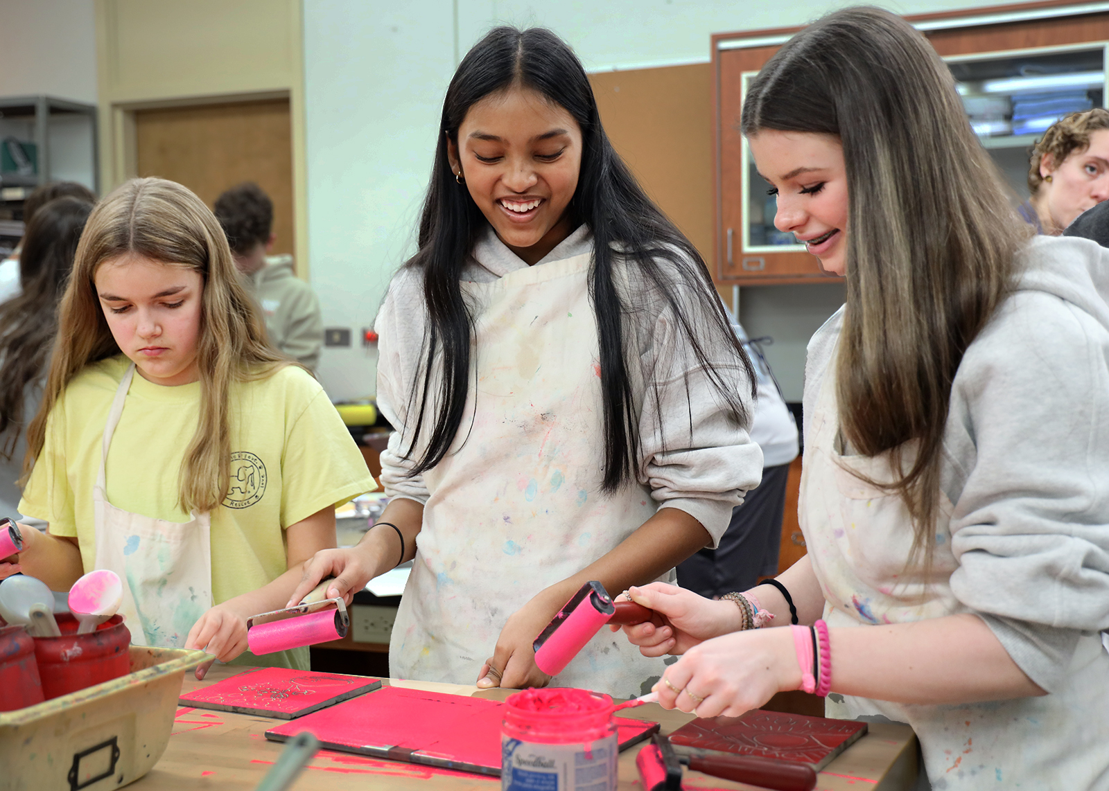students smile while working on art