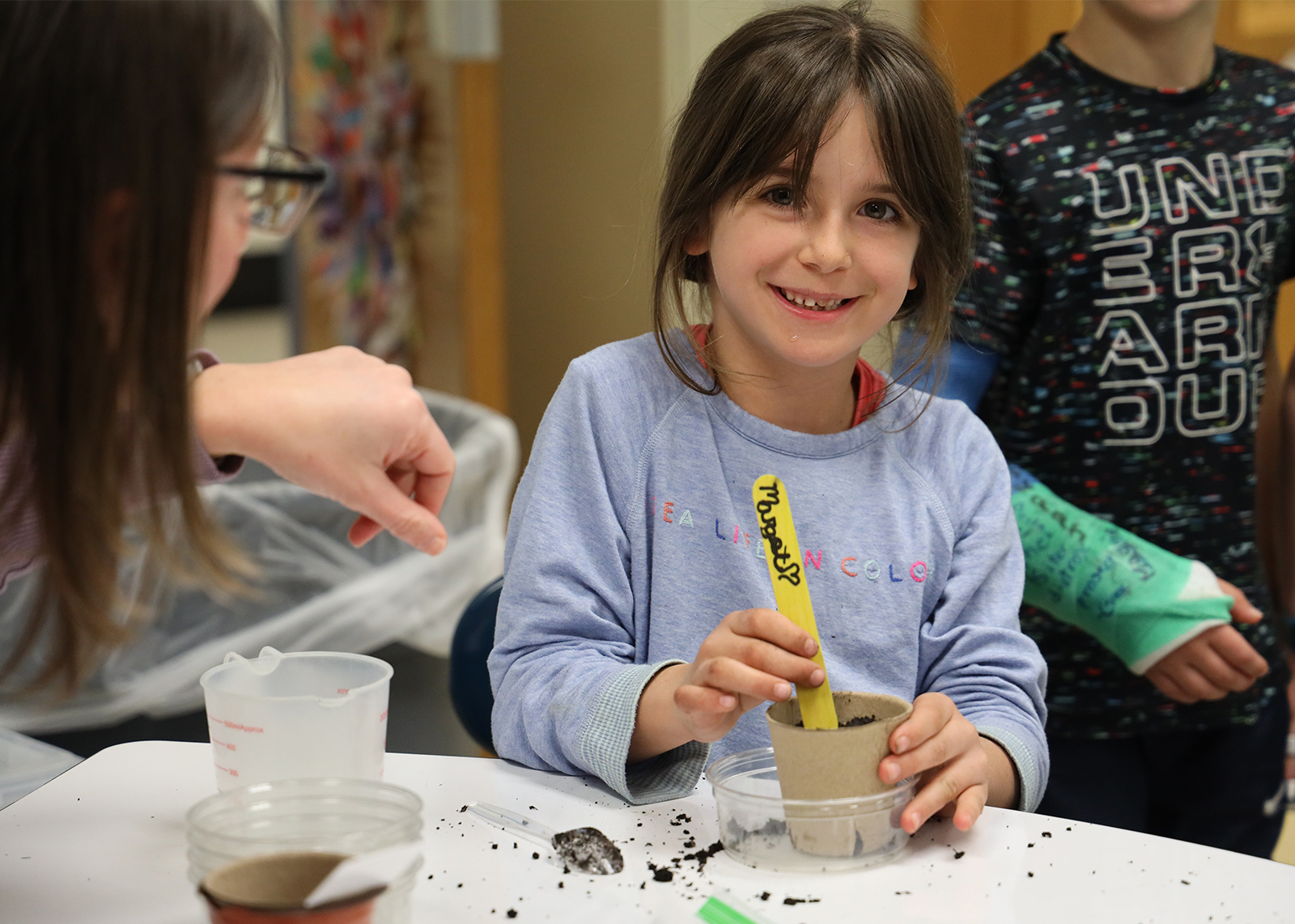 student planting seeds in dirt cup