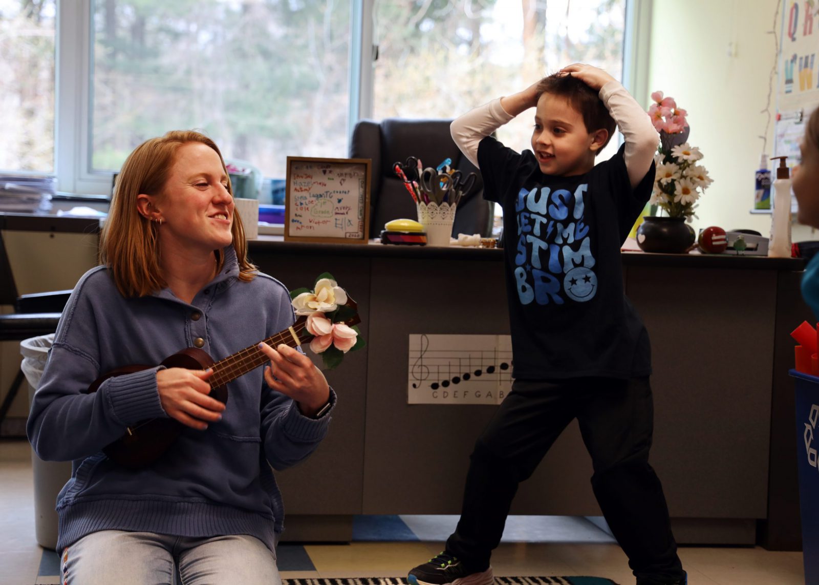 student dancing to teacher playing ukelele