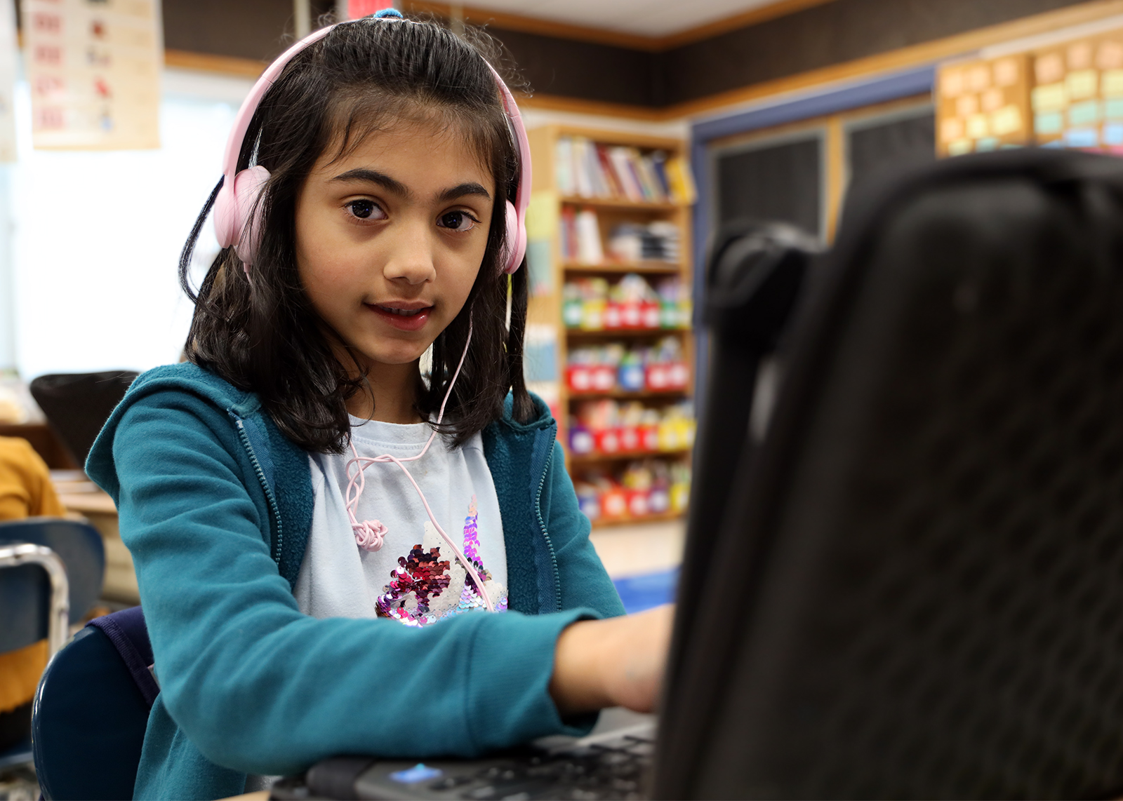 student smiling on chromebook