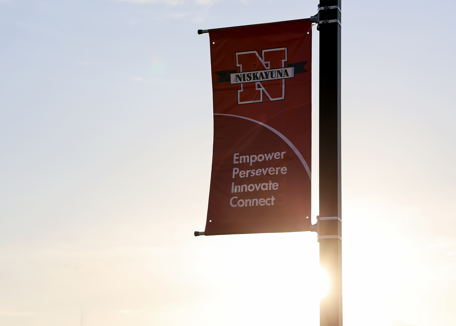 banner with nisky logo and words empower, perservere innovate connect with a sunset
