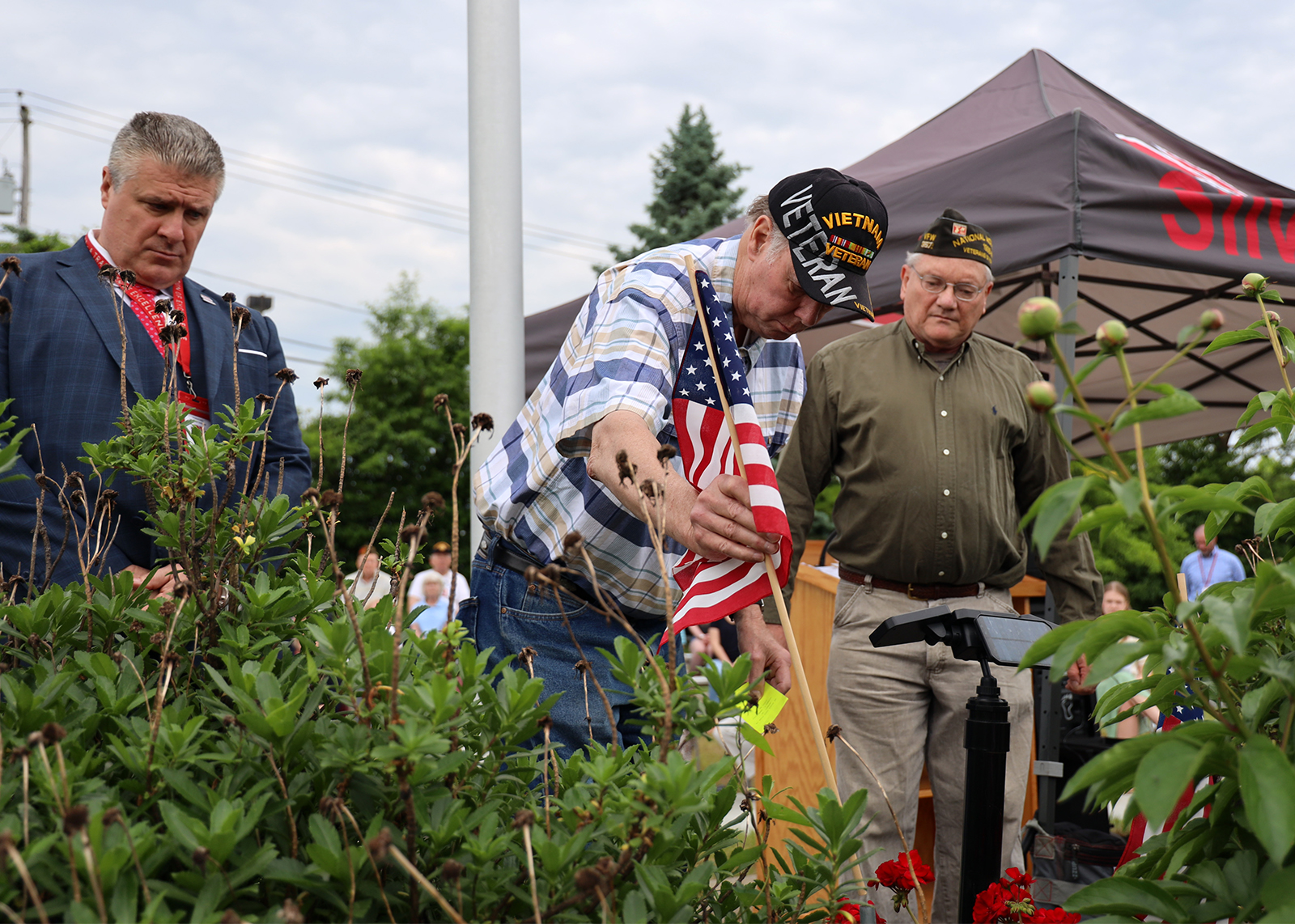 veterans put flags in ground at Memorial Day ceremony