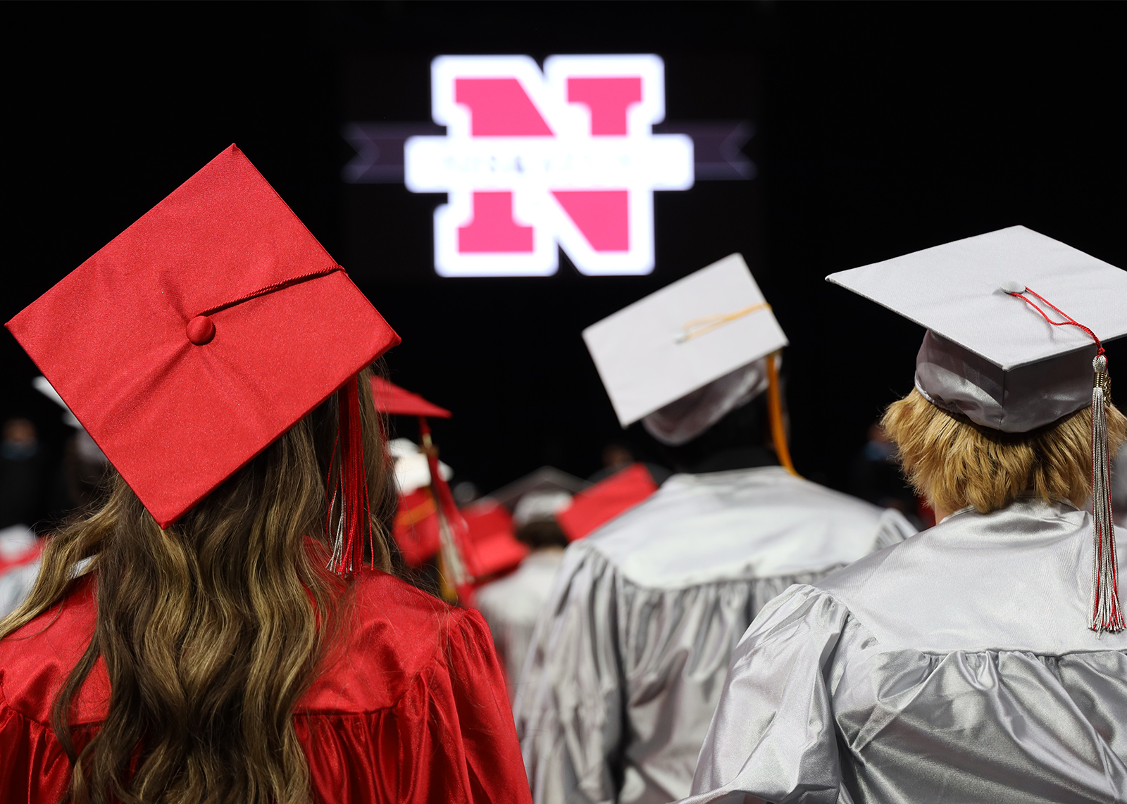 graduation caps in foreground with blurry school logo in background