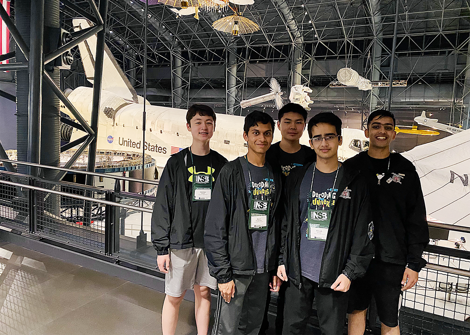 five high school students standing in front of united states plane