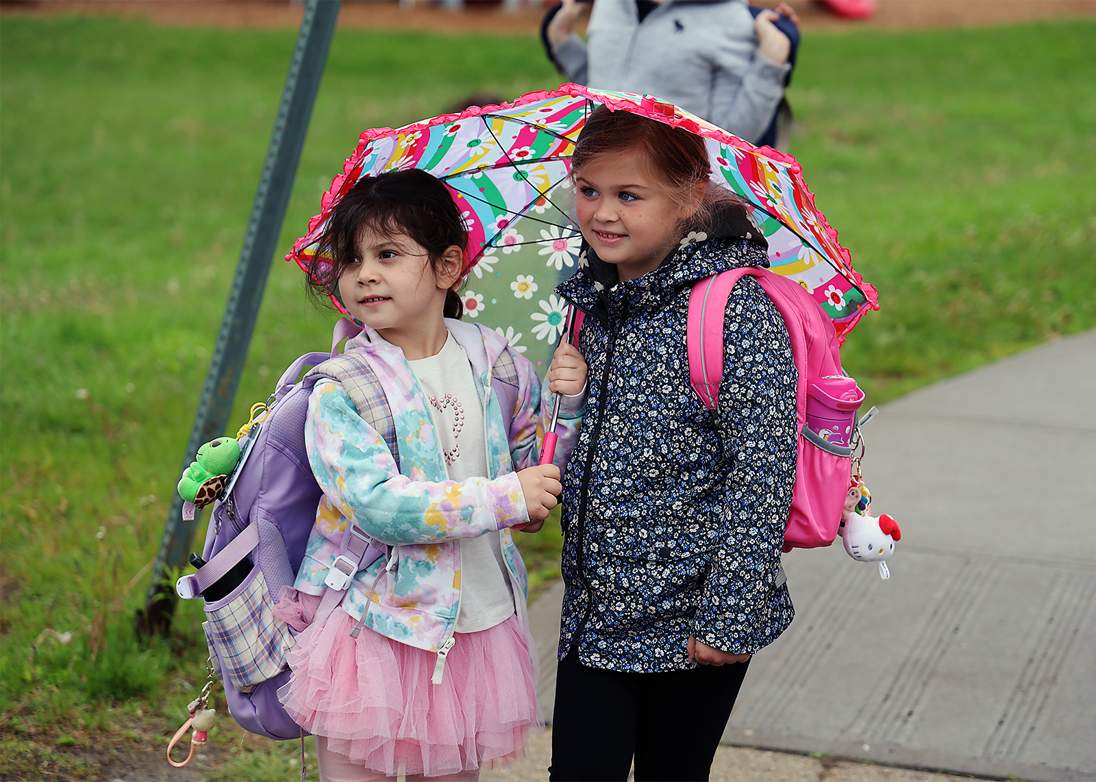 elementary students huddles under and umbrella