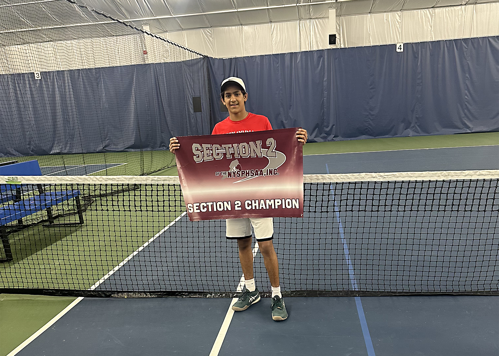 tennis player holding sign that says section 2 champion