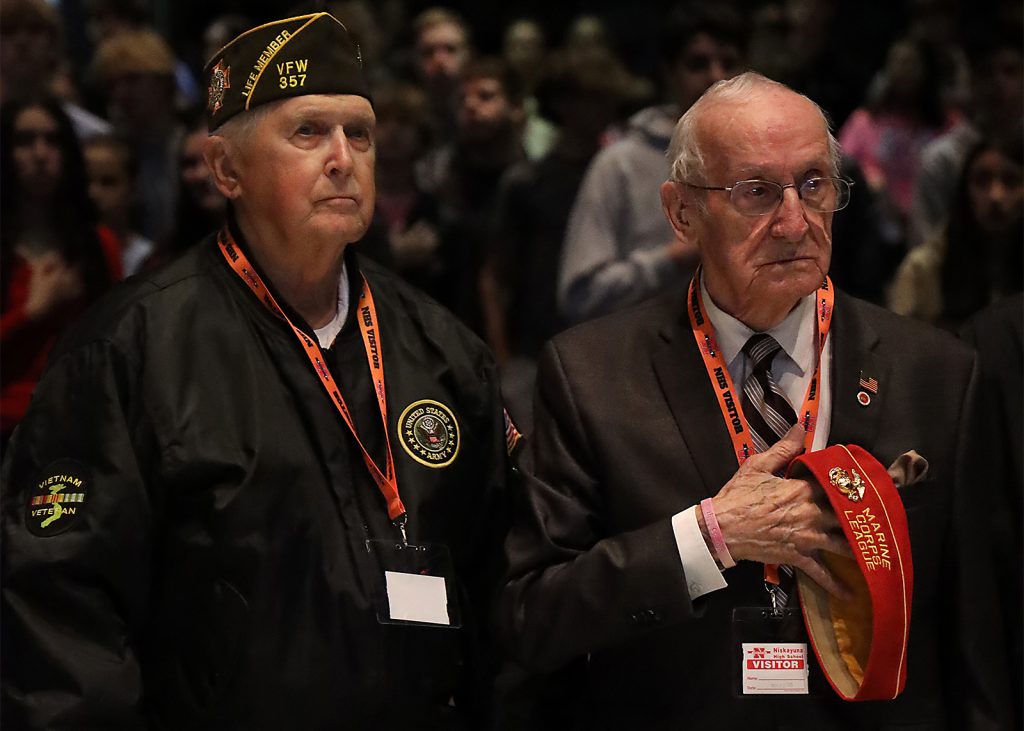 two veteran stand in the high school auditorium