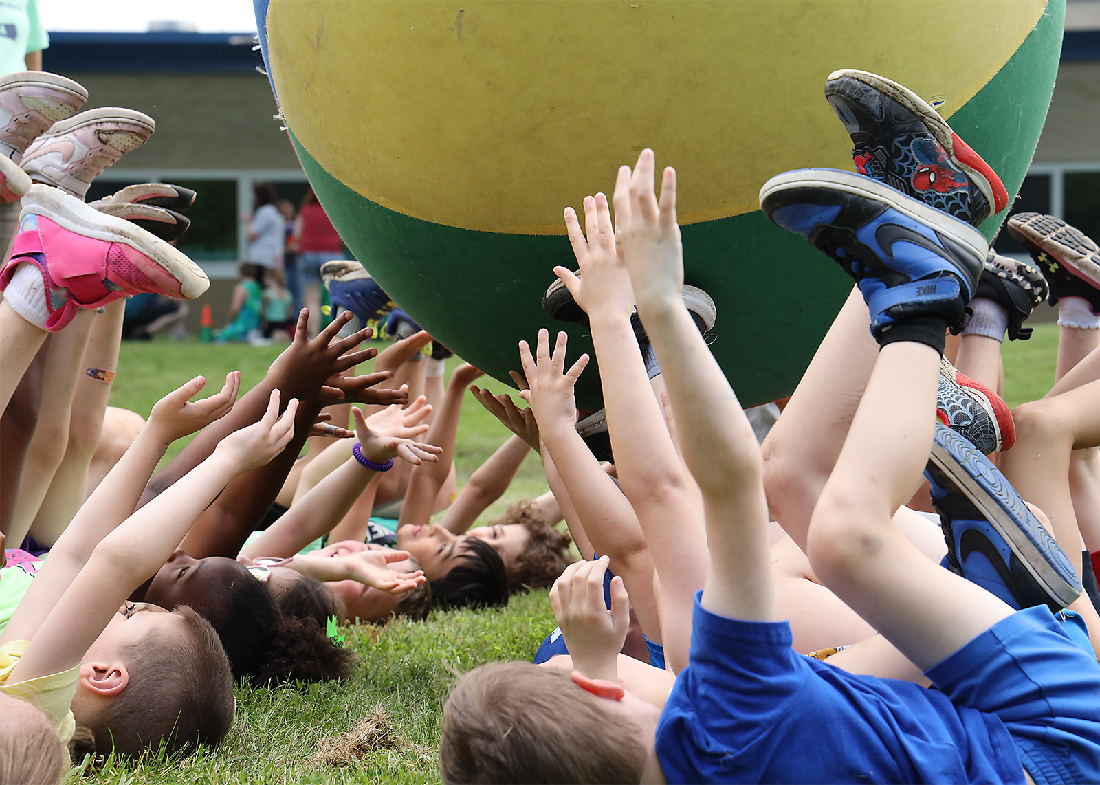 feet in the air keeping up a big colorful PE ball